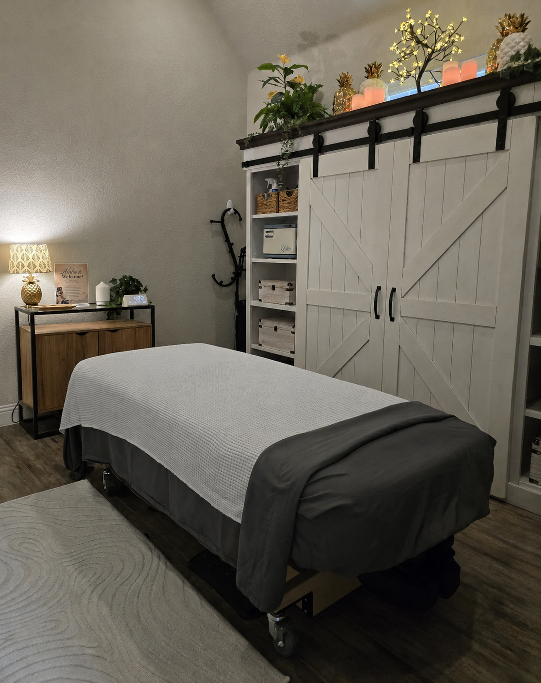 Michelle Reed's private treatment room with massage table and white barn-door cabinetry