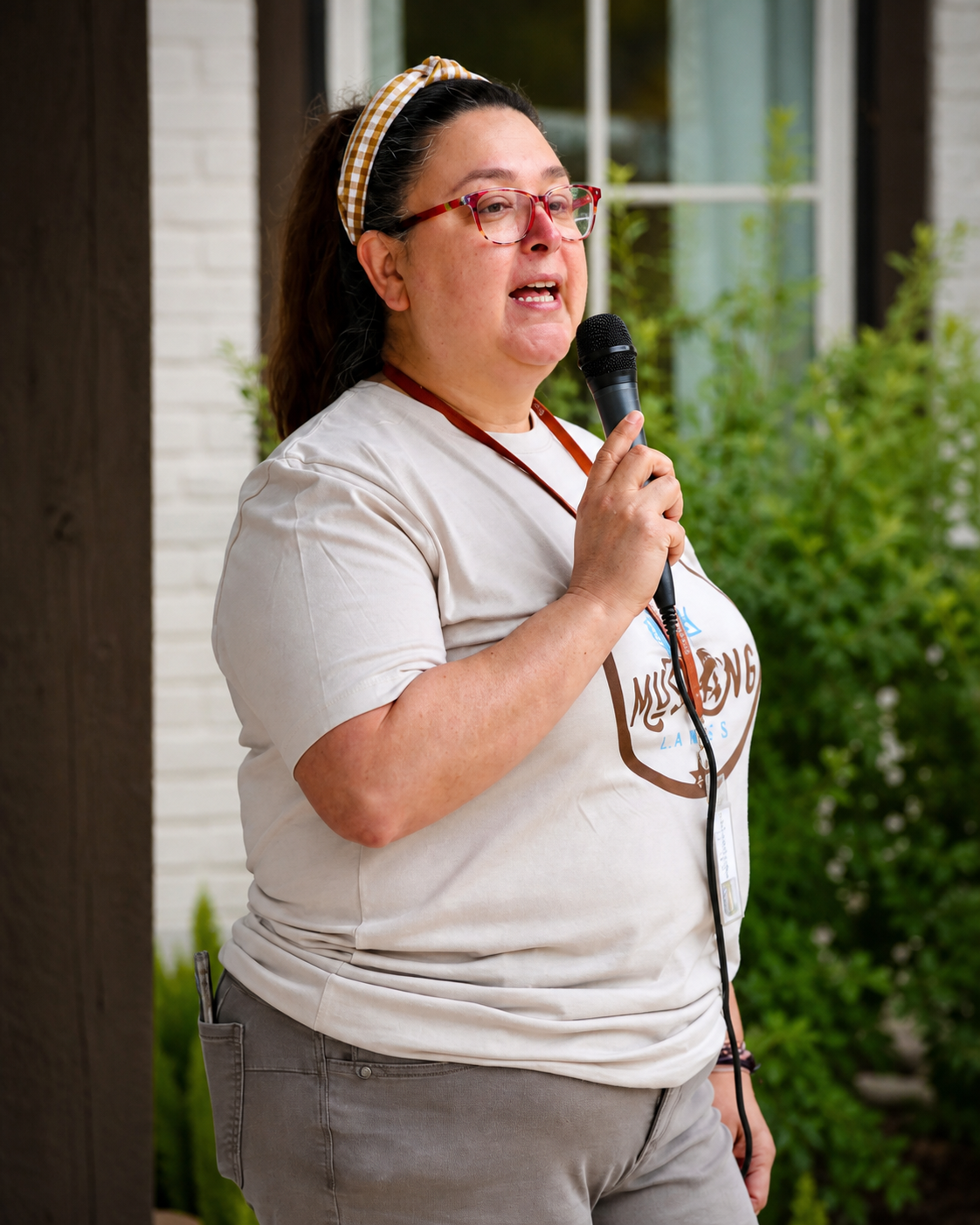 Michelle speaking into a microphone at a Mustang Lakes community event